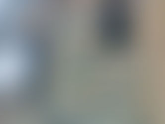 Partially constructed building with a stone facade in shades of gray and beige. Open window frames. Sky visible in the background.