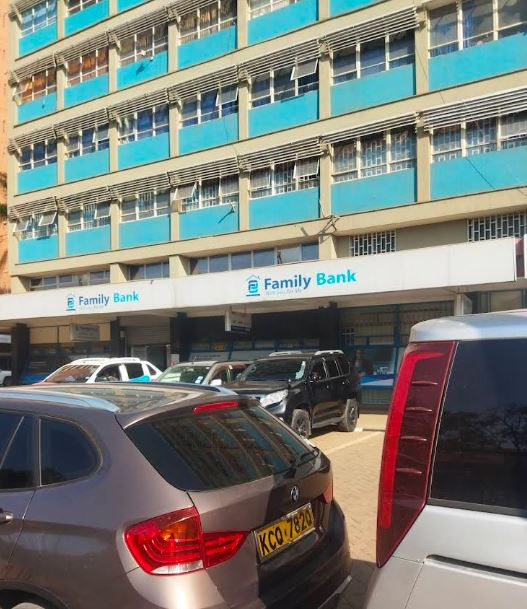 Family Bank branch in a blue office building, with parked cars in front and bright daylight on the street.