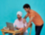 Coworkers collaborating at a laptop, showcasing workflow innovation, teamwork, and customised employee engagement strategies.