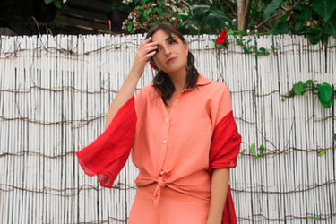 A model wearing the salmon-coloured, short-sleeved Zelda Shirt and 3/4 Balloon Skirt.