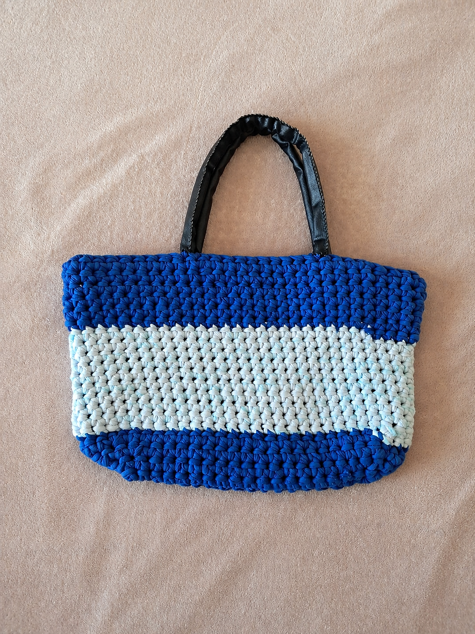 Sac en crochet bleu avec anses en simili cuir noir.