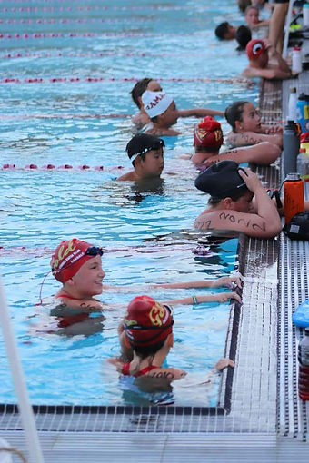 Swimmers resting on the wall during the Oakdale Aquatics Swim-a-Thon