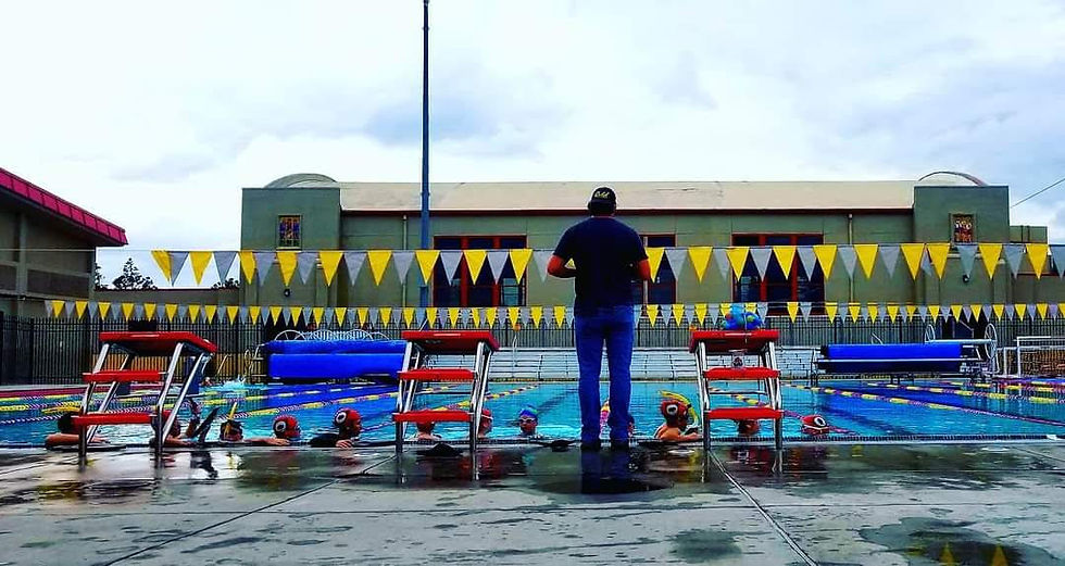 Coach Ronny explaining a drill as the swimmers prep to start the set.