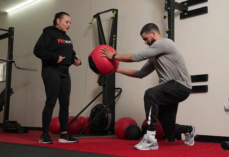 Personal trainer coaches man doing lunge with medicine ball