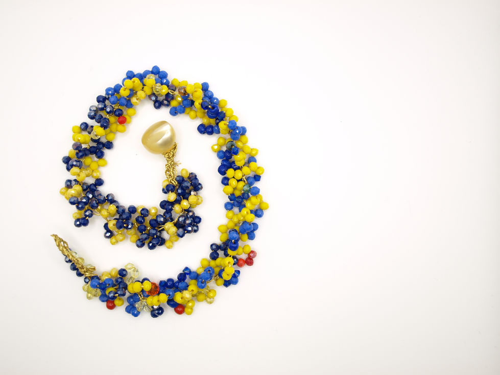 Collana girocollo con gruppi di cinque perline, di 3 mm, di colore azzurro e giallo, cucite su filo dorato.