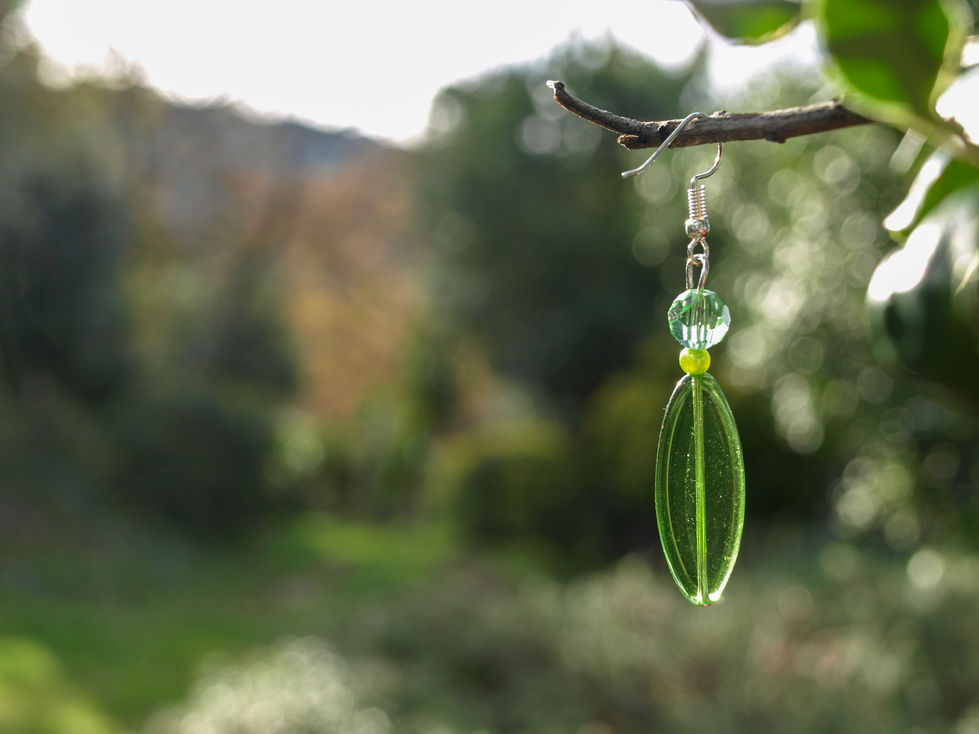 Orecchini con perla di 3 mm di colore verde, cristallo di 6 mm di colore verde transparente, e elemento ovale di colore verde transparente.