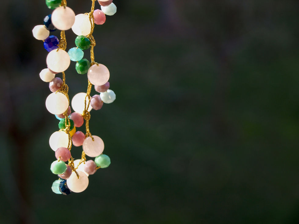 Collana girocollo, su filo cucito dorato, di perle di vetro, di varie dimensioni, piene e lisce, di varie tonalita' di marrone, fino a un beige chiaro; le perle di vetro sono accompagnate da perline di vario colore.