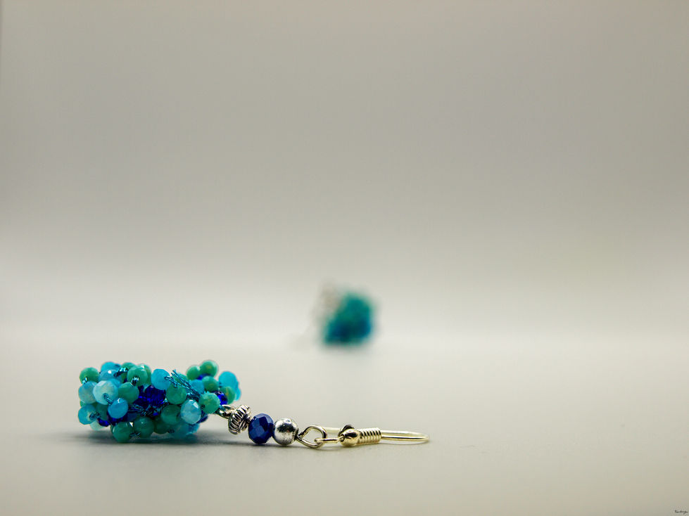 Orecchini a grappolo, con perline di colore azzuro, celeste, e blu, di 2.5 e 3.0 mm. Le perline sono chiuse da due perle di colore blu scuro, e color argento.