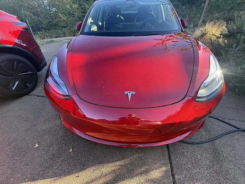 Red Tesla Model 3 rental plugged in at home in Salem, Oregon