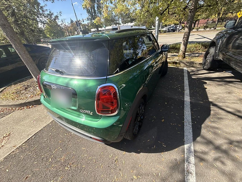 Green MINI Cooper SE electric rental from the ORCritters fleet, rear three-quarter view