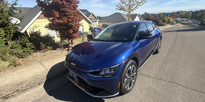 Blue Kia EV6 rental on a residential street in Oregon, three-quarter front view