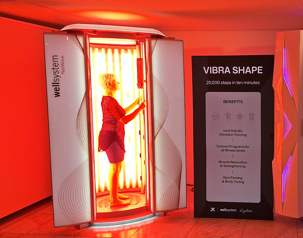 Kirsty demonstrating the RedWave Pure Booth - red light therapy and vibraplate training in