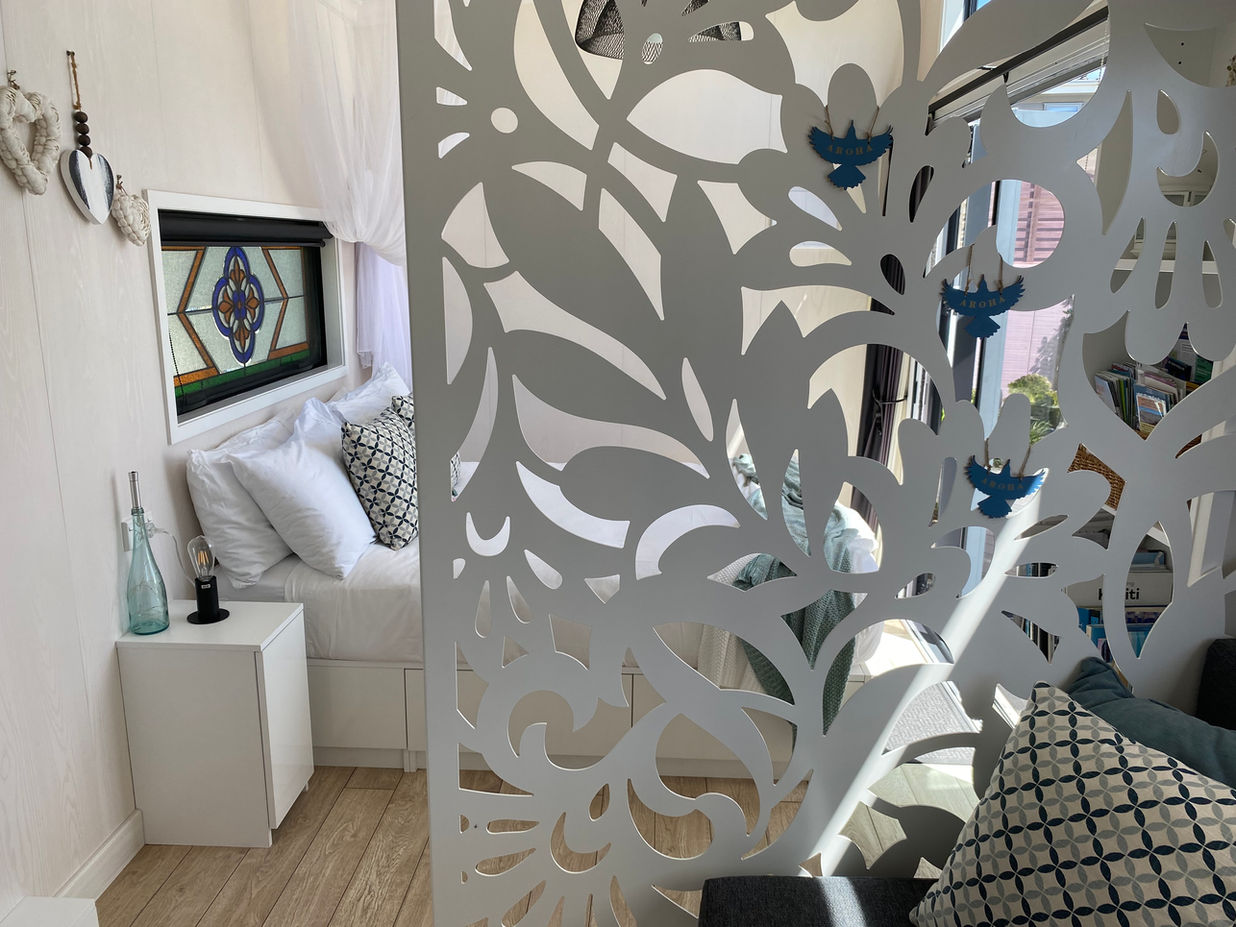 Bed with decorative screen between the rest of the tiny house - Aroha Tiny House B&B, Peka Peka, Waikanae, Kapiti