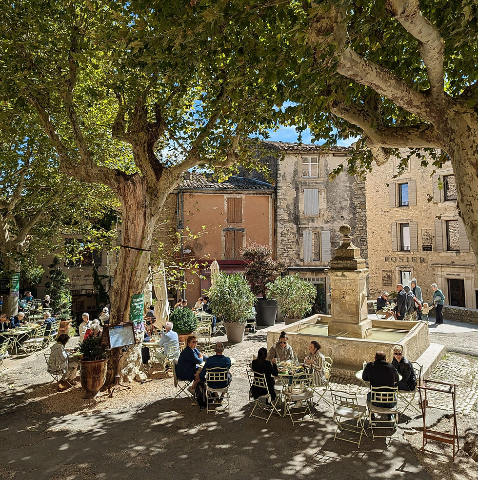 people sitting outside in cafe in a village square