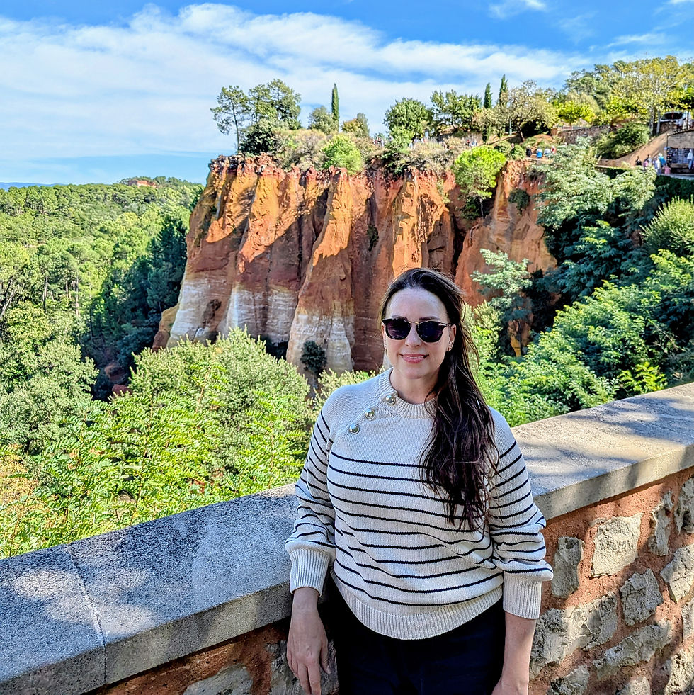 woman standing in front of a view of a cliff and forest