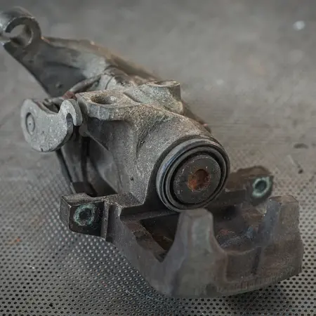 Étrier avant démontage, piston grippé et dépôts de rouille apparents
