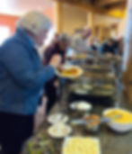 Staff and volunteers getting lunch down a buffet serving station