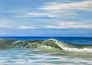 Wave breaking on the shore, sunny day with blue skies