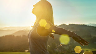 Person standing confidently at sunrise symbolizing personal growth, self-discovery, identity alignment, and becoming the person they were meant to be.