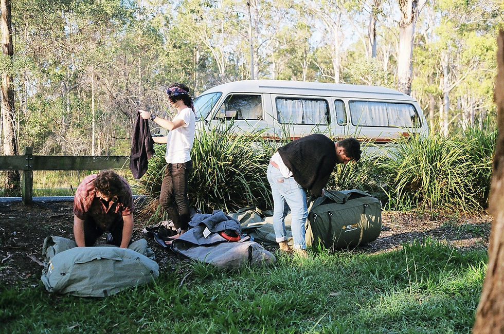 A man outdoors holding a heavy grey duffel bag