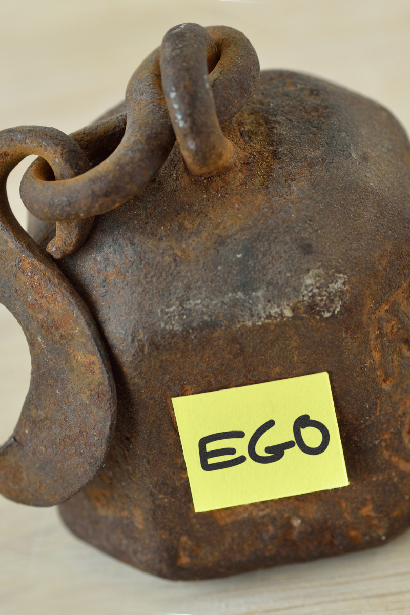 Weight with a postit note that says ego on it