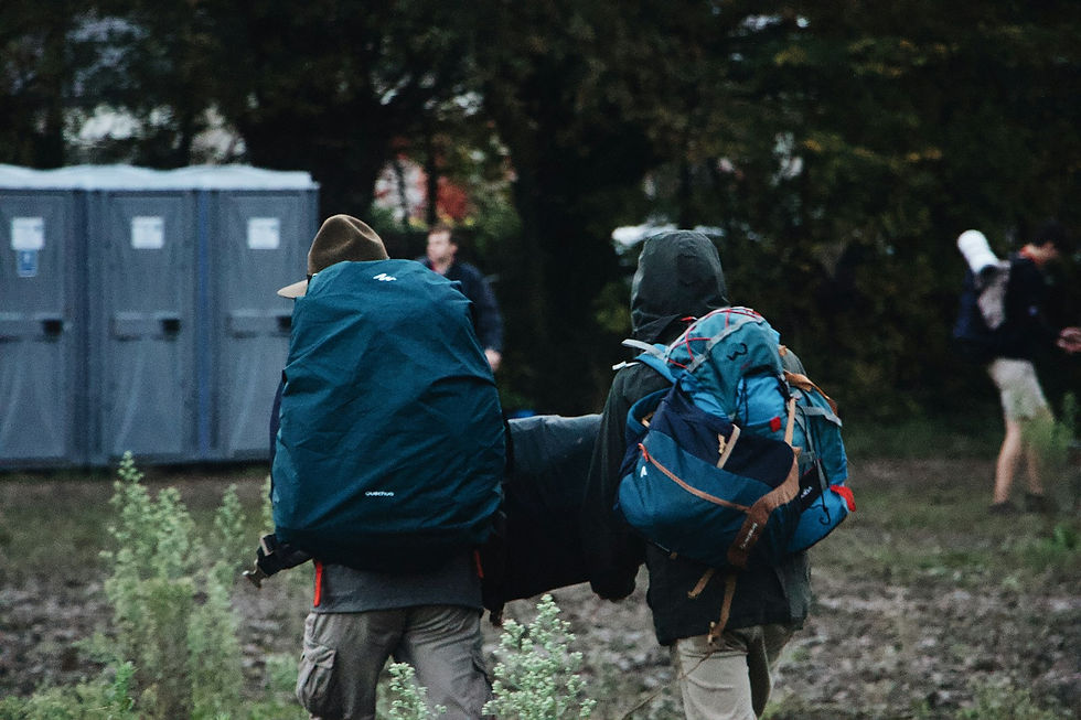 People walking a trail carrying bags and gear