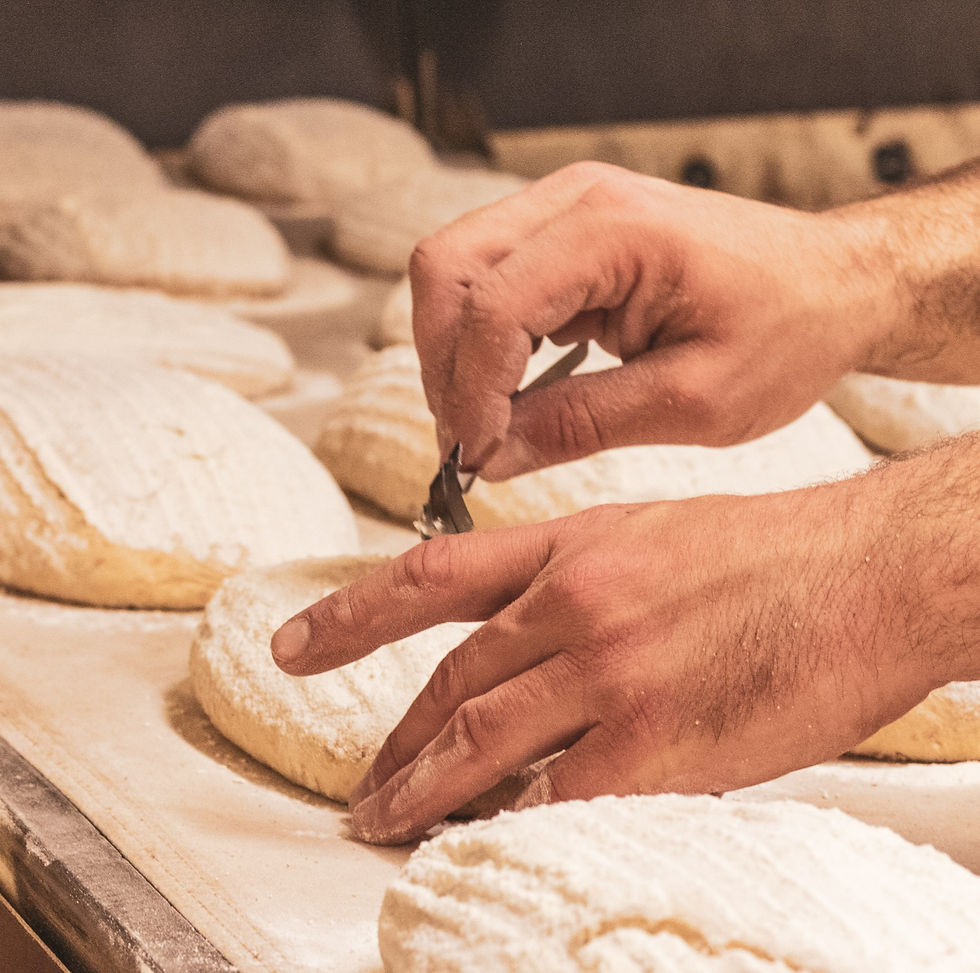 bakers hands carving shapes into some dough before baking