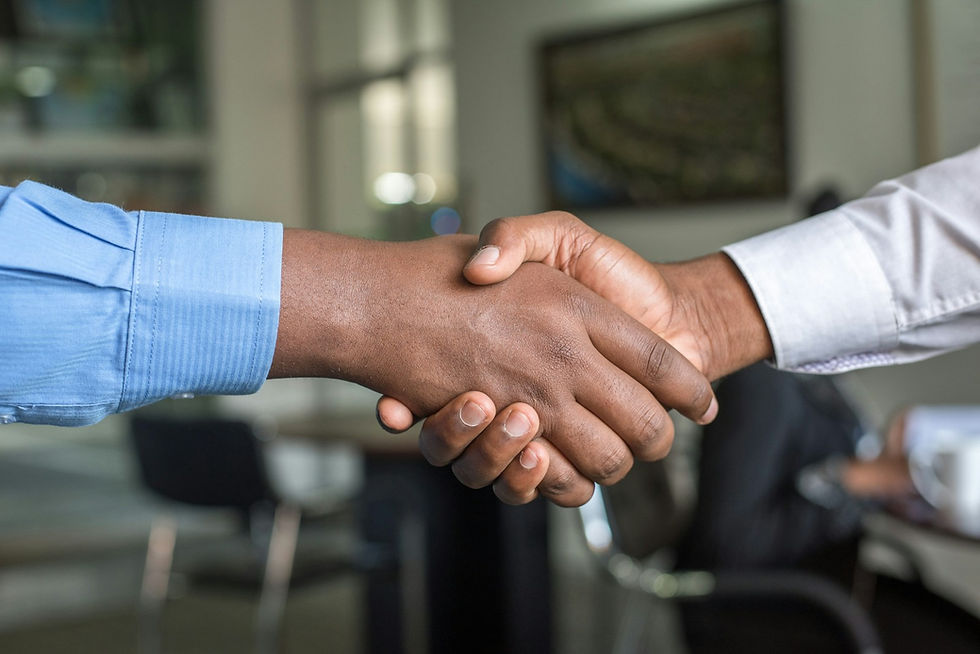 Two people shaking hands in a bright office