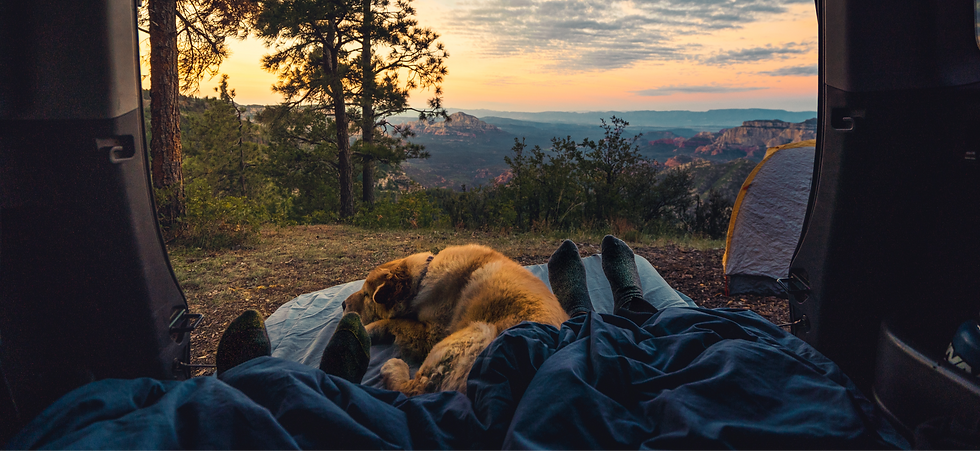 perspective of two people laying down camping with a mountain landscape before them