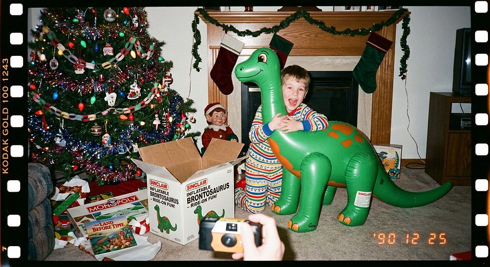 kid on christmas day in the 90's opening a inflatable dino
