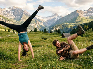 two people attempting to do cartwheels in a meadow in the mountains
