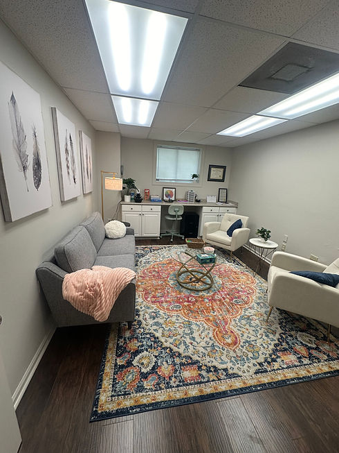 Lauren's Office: a navy, orange, and pink rug with cozy gray couch and two white armchairs.