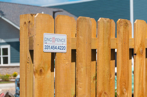 Wooden fence with DNG FENCE sign and phone 331.454.4220