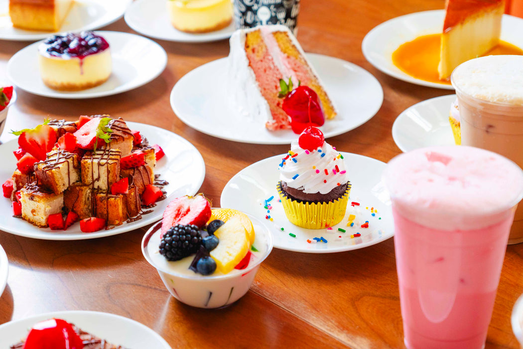 Assorted cakes, pastries, and drinks on table