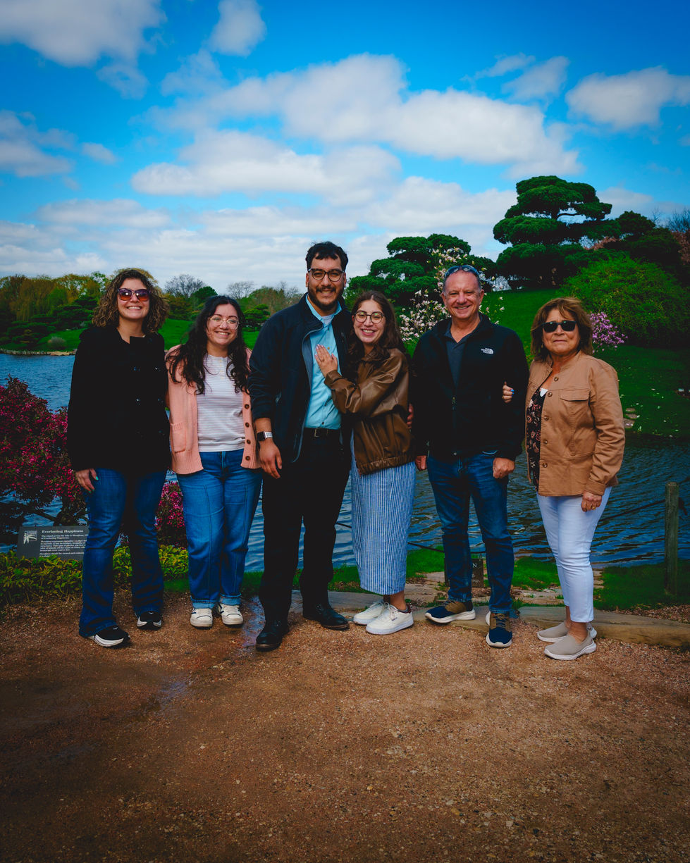 Group of people posing in a park setting.