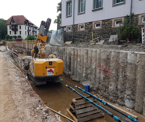 In eine Stützwand bohrt die Jähnig GmbH Löcher für eine Rückverankerung.