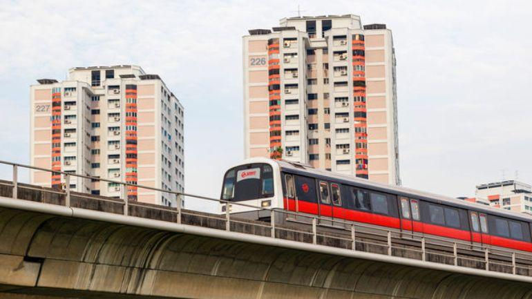 Modern residential buildings located near a new urban rail line.