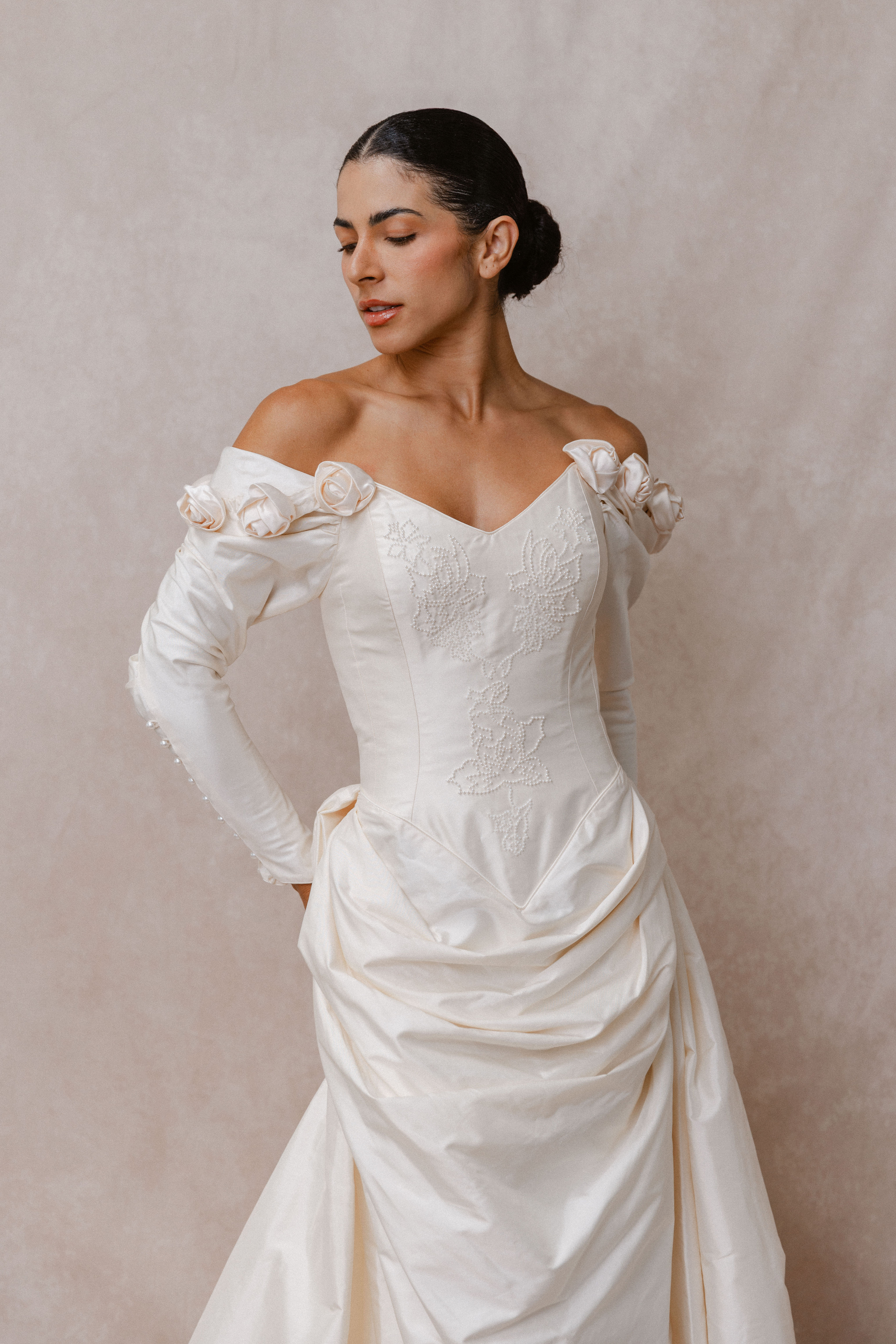 Model wearing Catherine Rayner Louisa wedding dress against beige backdrop