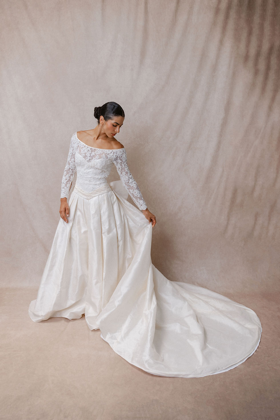 Model wearing vintage Christian Dior wedding dress against beige backdrop