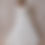 Thumbnail: Red-haired model wearing a vintage Catherine Rayner wedding gown with rosettes against a beige backdrop.