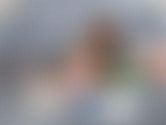 Mother and daughter playing with a blue steel tongue drum and therapy toys on the floor during a bonding activity.