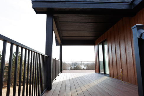 Large composite upper deck with scenic view and black aluminum railing built by Lake Lumber.