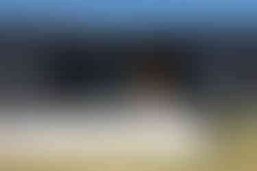 Modern home with sleek black exterior siding and light wood front door remodeled by Lake Lumber.