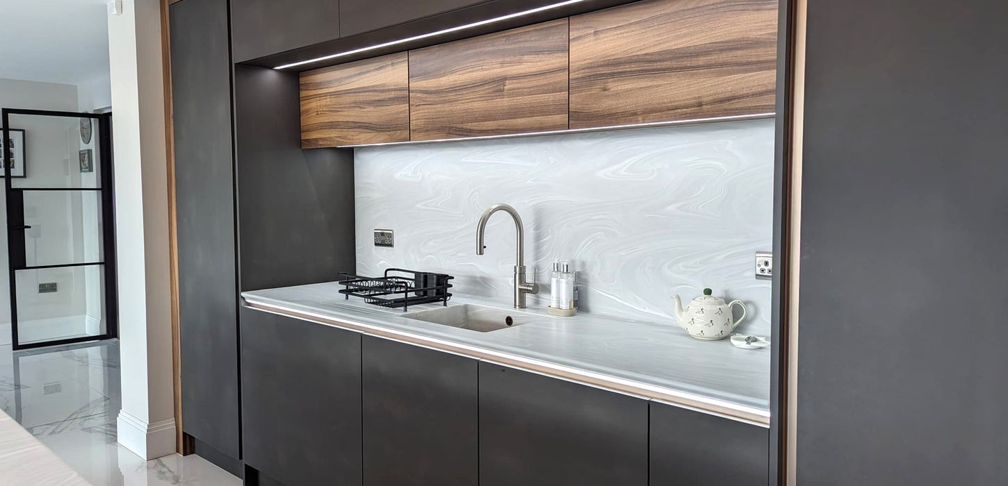 Bespoke handleless kitchen in Wirral with dark anthracite cabinets, walnut details and Corian worktops