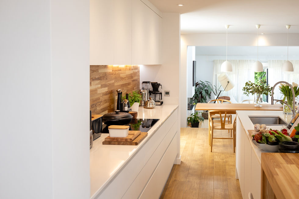 Bright modern white kitchen with wood accents, island sink, pendant lights, and fresh produce on the counter, calm and airy