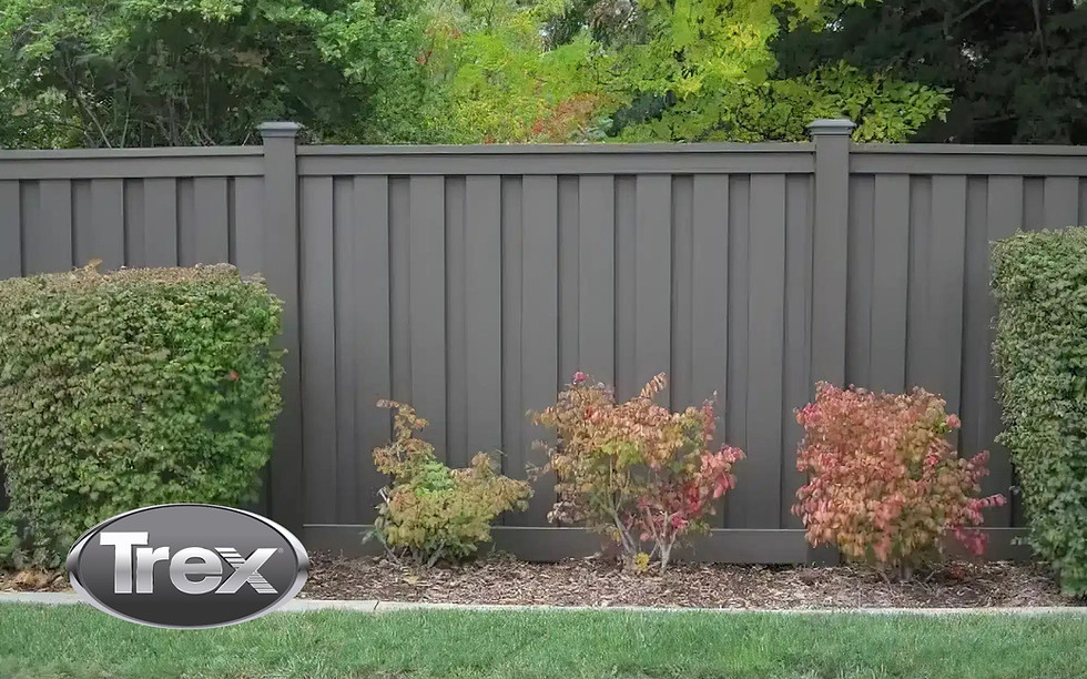 Trex gray composite privacy fence with landscaped shrubs
