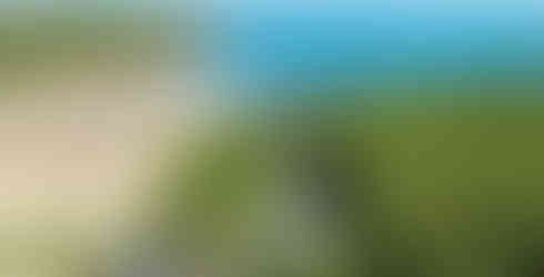 Avalon, a luxury coastal home above Maenporth Beach near Falmouth, Cornwall, offering panoramic sea views across Falmouth Bay. This three storey detached house features a front terrace overlooking the coast, landscaped gardens and a patio designed for al fresco dining. Interior images show a spacious open plan kitchen and dining room with Shaker style cabinetry and freestanding cooker, a glazed conservatory opening onto the garden, a comfortable sitting room with French doors, and a snug with garden views. Four double bedrooms include en suite bathrooms and a dual aspect principal suite, making this an ideal family home in Maenporth. The property also includes an integral garage, utility room, summer house suitable for a home office or studio, and private parking, presented by Jackson-Stops Cornwall with a guide price of £1.3 million.