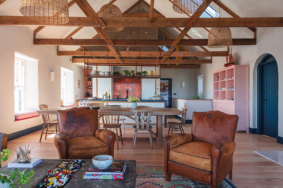 The ceiling was opened up to expose the beams and trusses, and the house furnished in vintage finds