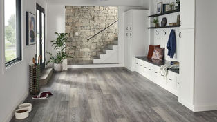 Mud room with light grey flooring with white cabinets and a built in bench.