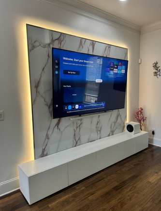 Custom media wall with floating TV stand and marble-look panel in Tampa Bay